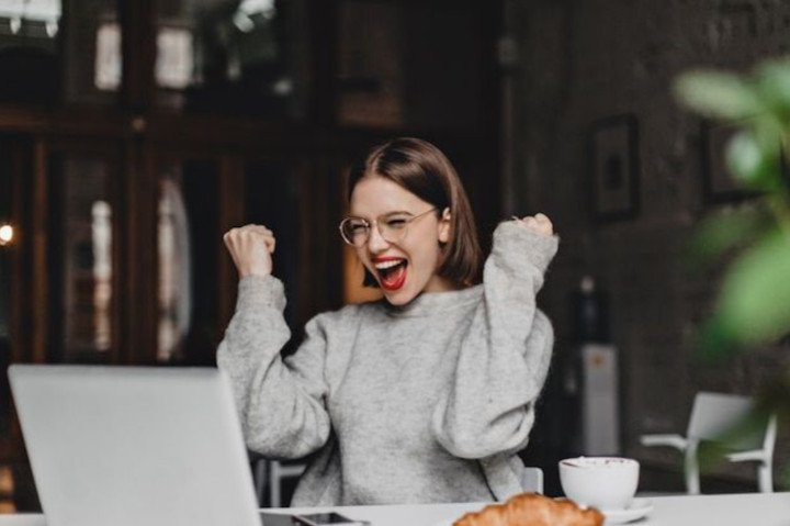Woman is happy in front of a laptop