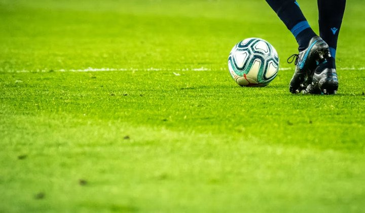 Football player with a footbal ball on the field.